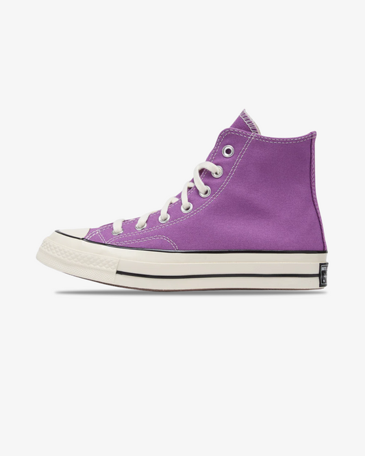 A single purple high-top sneaker with white laces, a white rubber toe cap, and a white midsole with a thin black stripe, shown in profile against a light gray background.